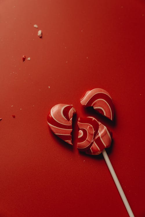 Close-Up Photo of a Red Broken Heart Shaped Lollipop