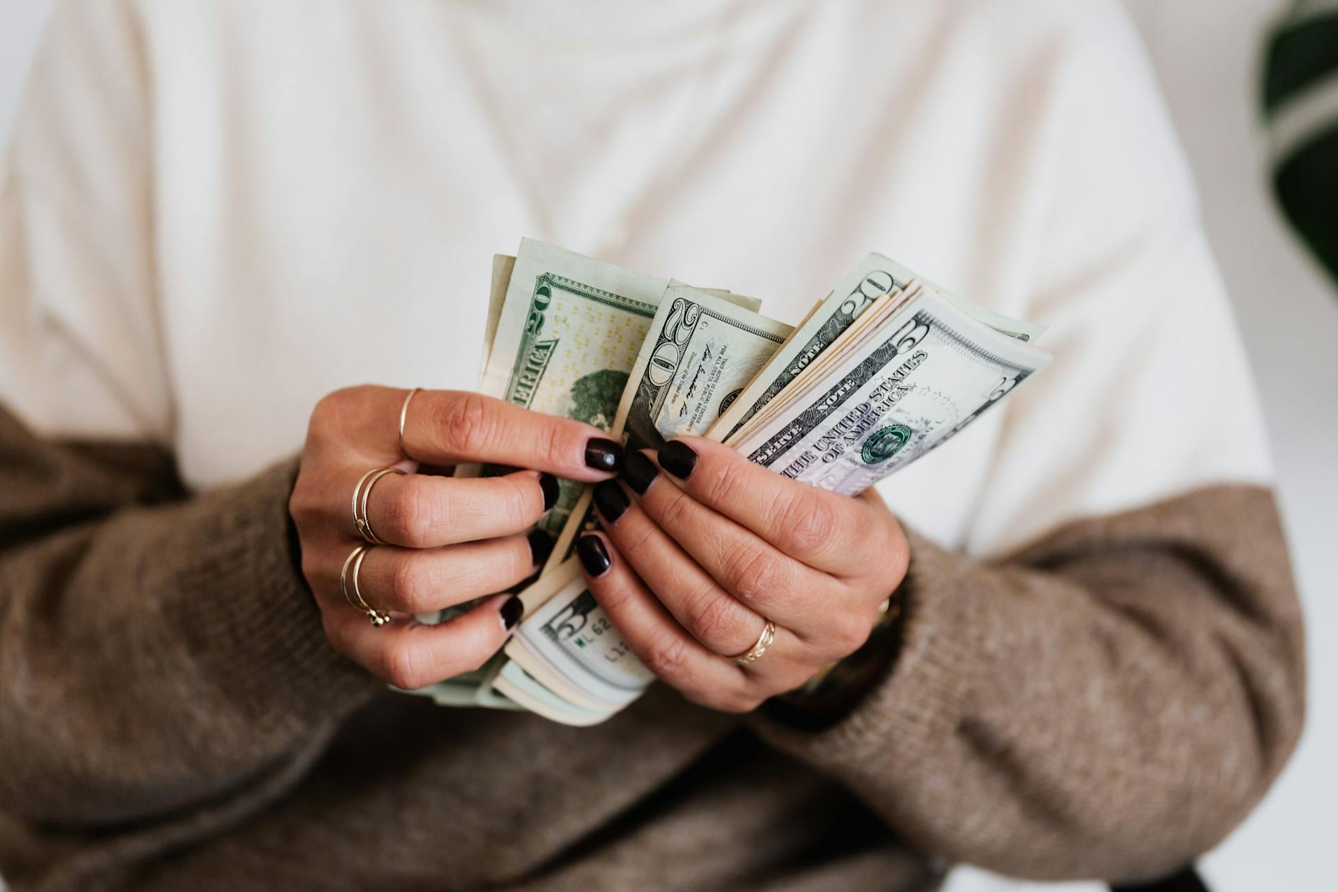 Close-Up Photo of a Person Counting Her Money