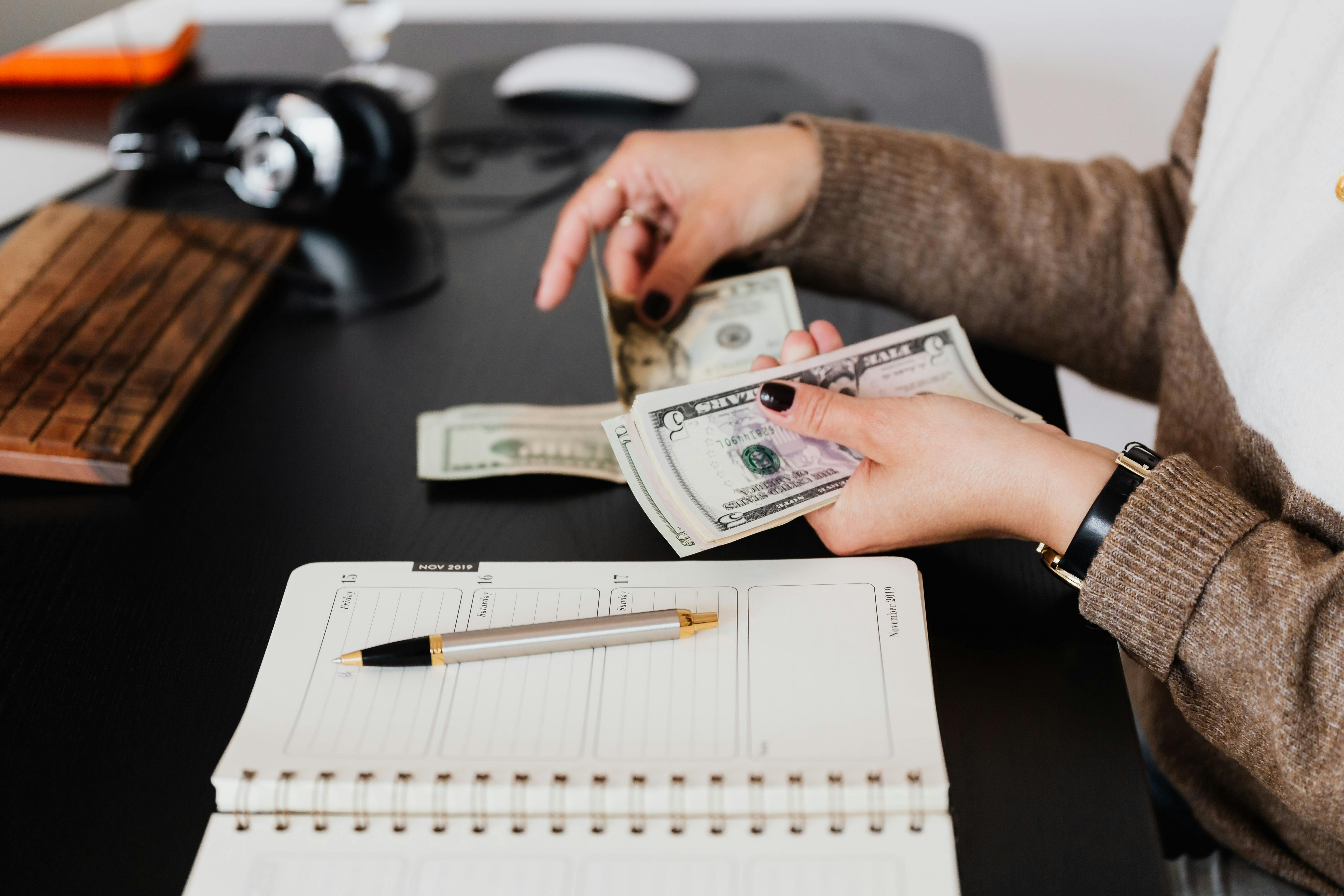 Crop businesswoman counting money while sitting at desk \u00b7 Free Stock Photo