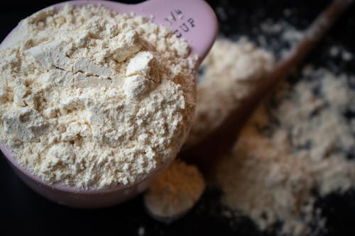 Shallow Focus Photo of a Measuring Cup Filled with Flour