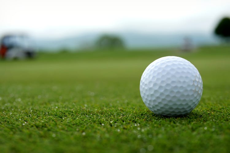 White Golf Ball On Green Grass Field