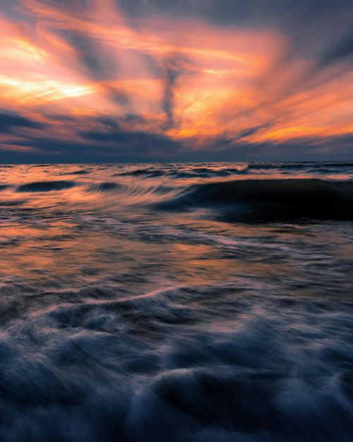 Free Majestic view of stormy sea with foamy waves under vivid sundown sky in long exposure Stock Photo