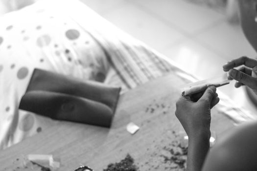 Unrecognizable person making cigarette at home