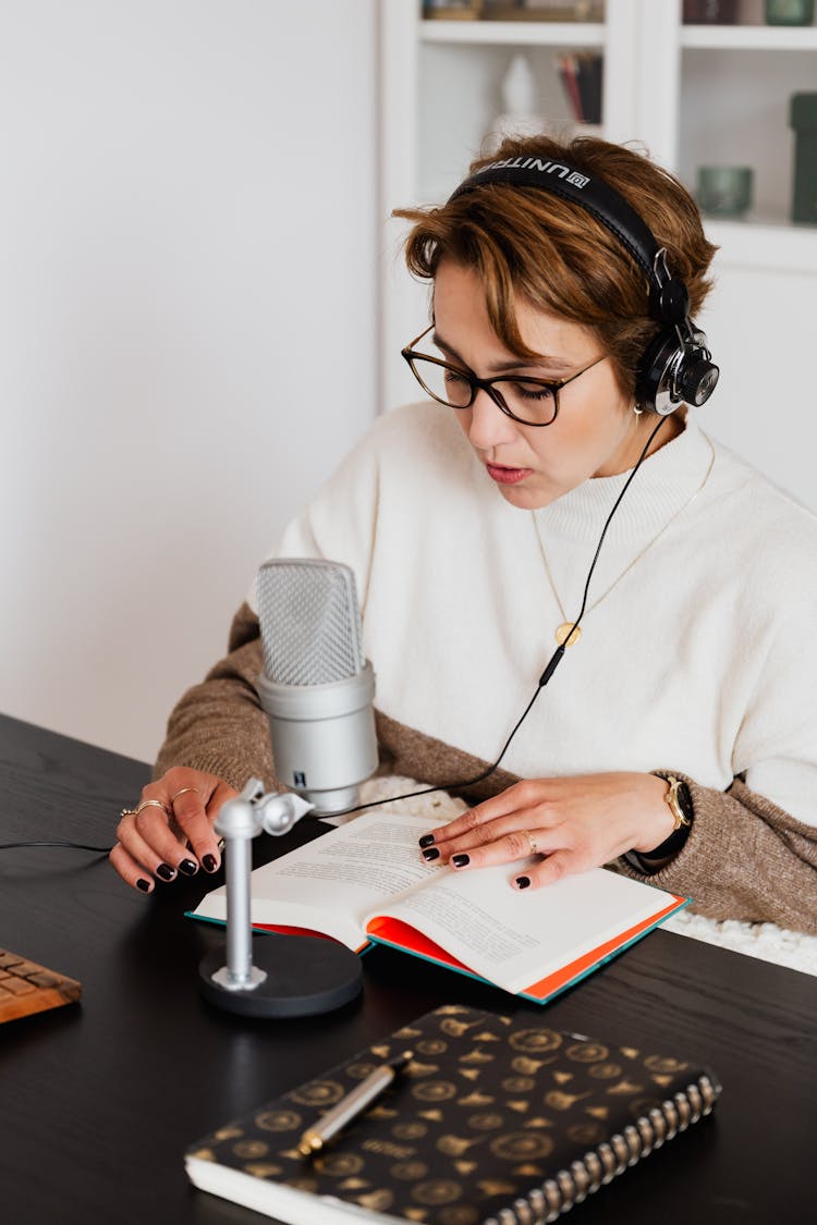 Woman Reading A Book While Wearing Headphones