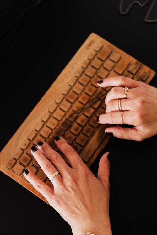 Crop woman typing on wireless keyboard