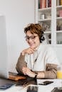 Cheerful woman in headphones using computer
