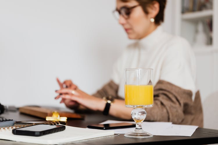 Crop Woman Working At Table With Computer Keyboard And Gadgets