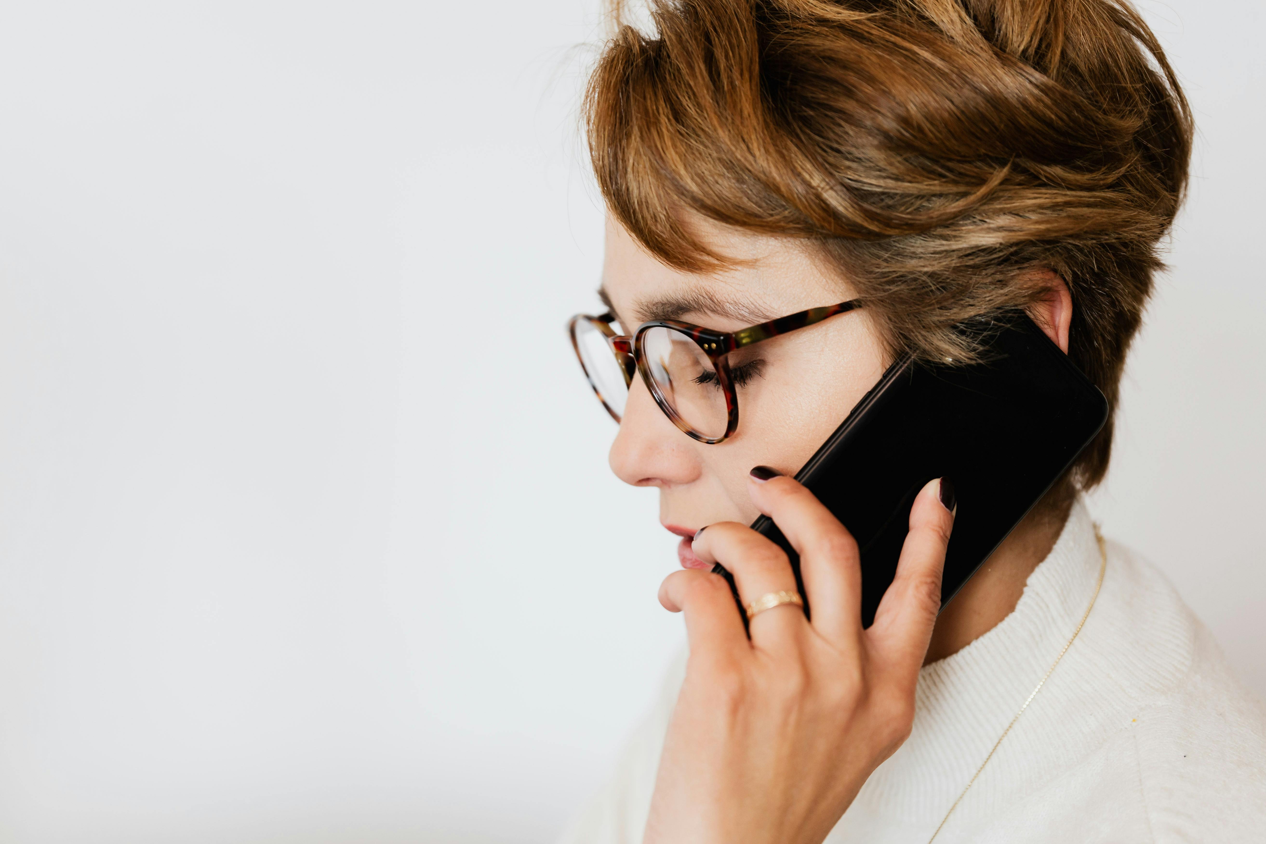 Thoughtful adult woman talking on smartphone · Free Stock Photo