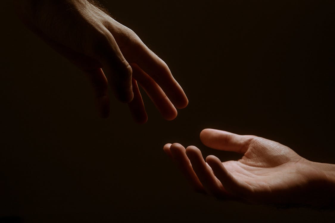 Free Persons Hand on Black Background Stock Photo