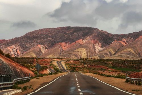 Free Straight wet asphalt roadway on background of amazing mountain range under cloudy sky Stock Photo