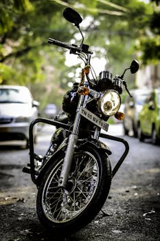 Close-up of a Royal Enfield motorcycle parked on an urban street with a blurred background.