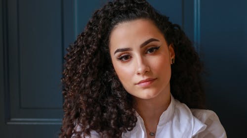 Charming woman with curly hair looking at camera