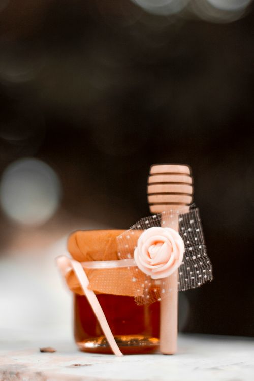Free Stylish jar of honey adorned with a flower and decorative stick, perfect for gourmet presentation. Stock Photo