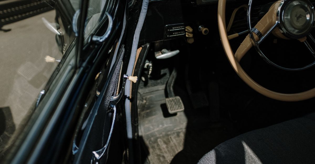 Close-up shot of a classic car interior showcasing steering wheel and dashboard.