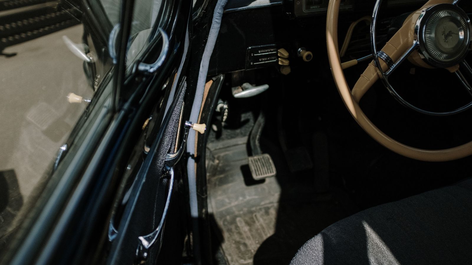 Detalhe do volante, banco do motorista e pedais durante a inspeção de um carro usado