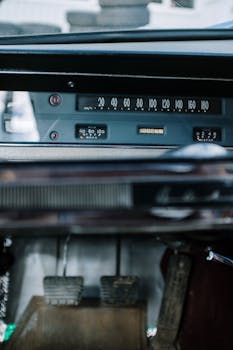 Close-up of a vintage car dashboard featuring retro dials and pedals, capturing automotive nostalgia.
