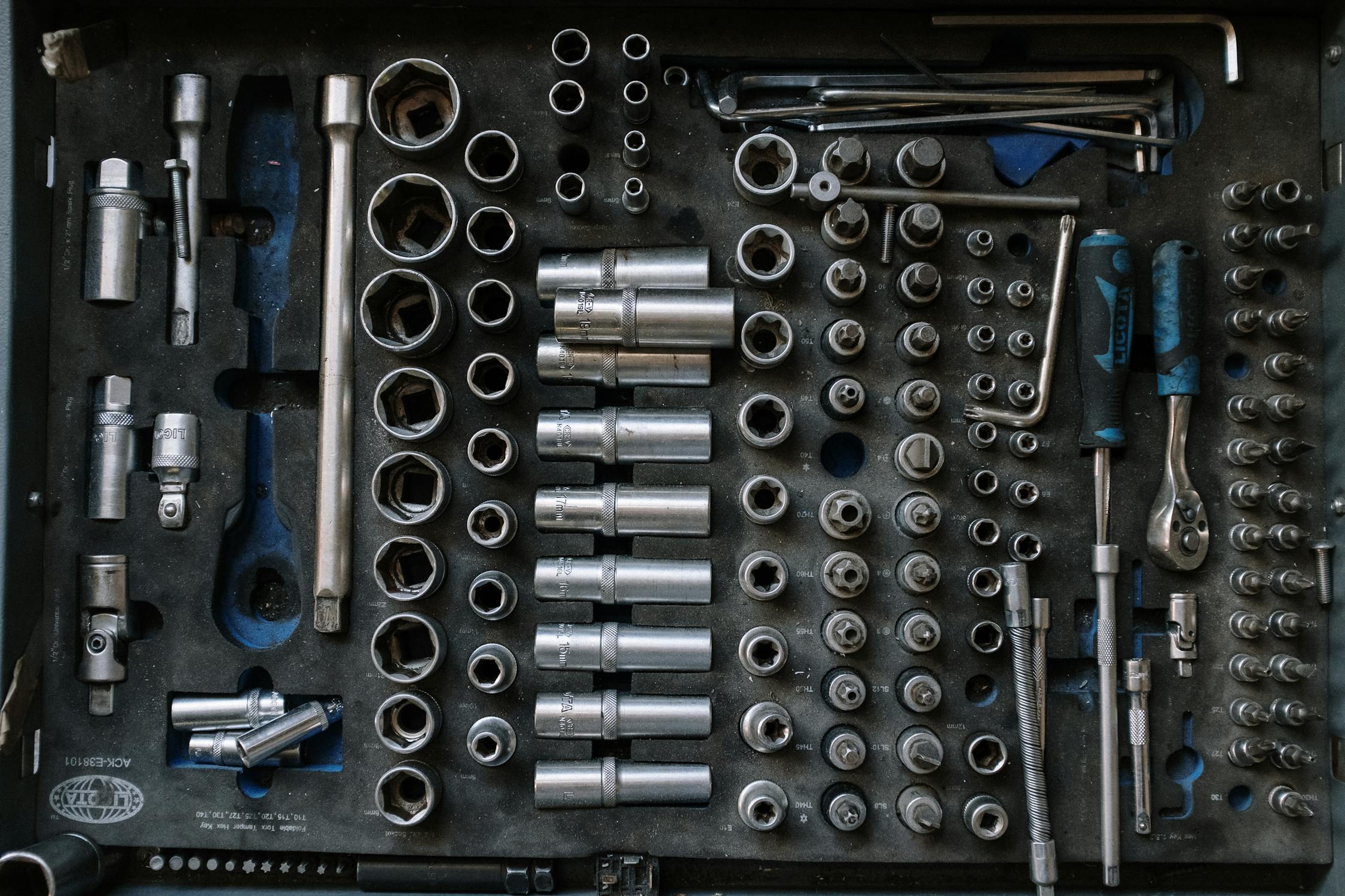 A selection of silver tools in a tool kit. 