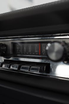 Close-up of a vintage car radio dashboard with frequency display and control knobs.