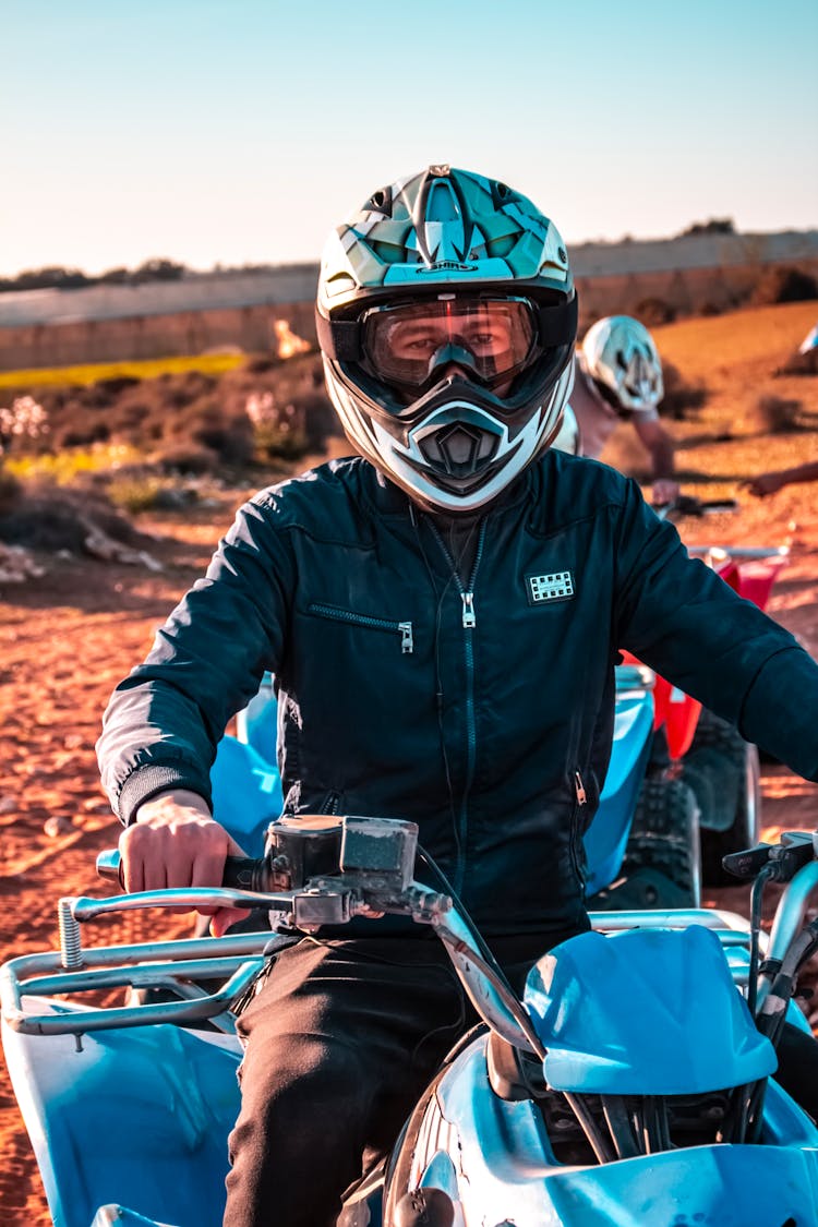 A Man Wearing Helmet Riding An ATV