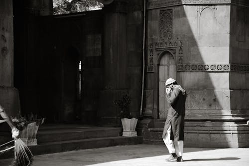 Monochrome Photo of a Man Walking Towards the Mosque