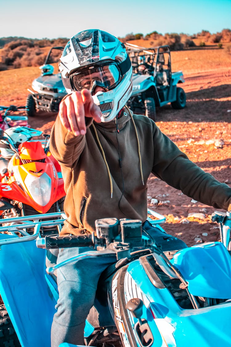 A Man Wearing Helmet Driving An ATV