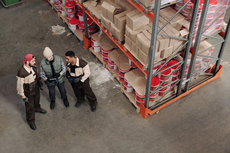 Men Standing In A Warehouse Talking