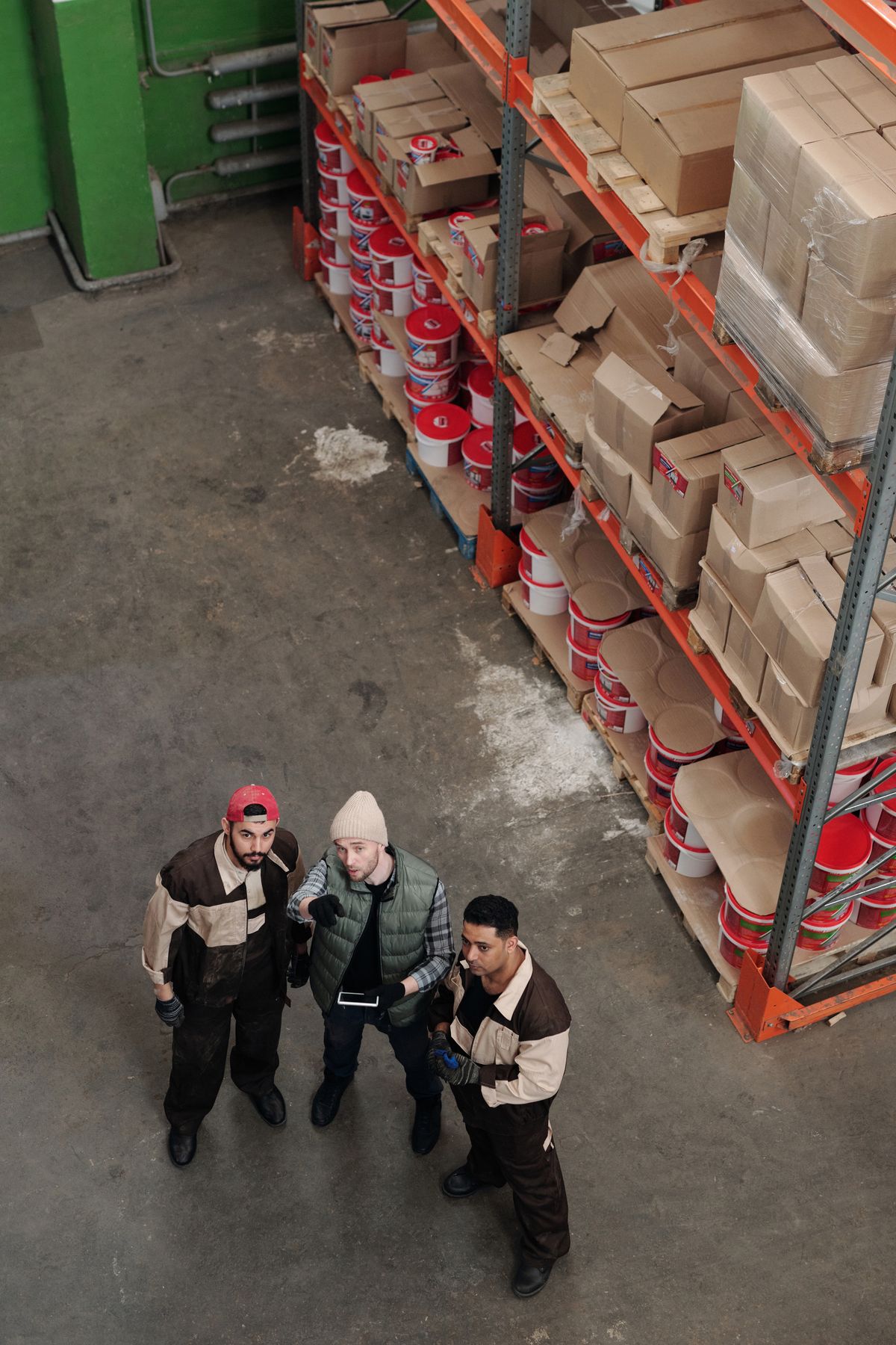 Warehouse team discussing logistics beside organised stock shelves