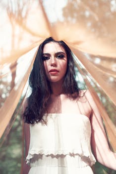 柔和的阳光下，飘逸的窗帘环绕着一位户外女性的艺术肖像