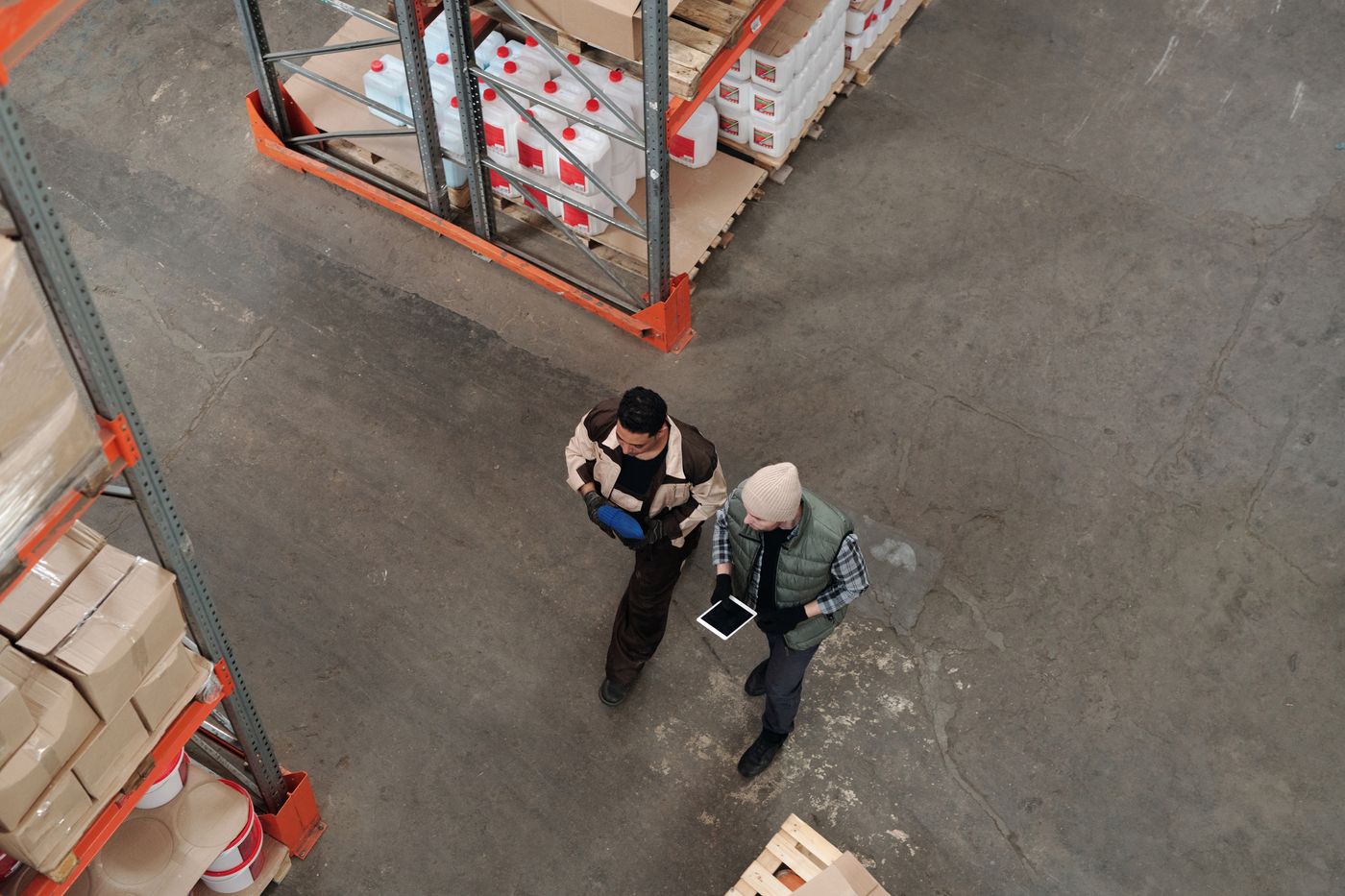 Two workers coordinating inside a warehouse