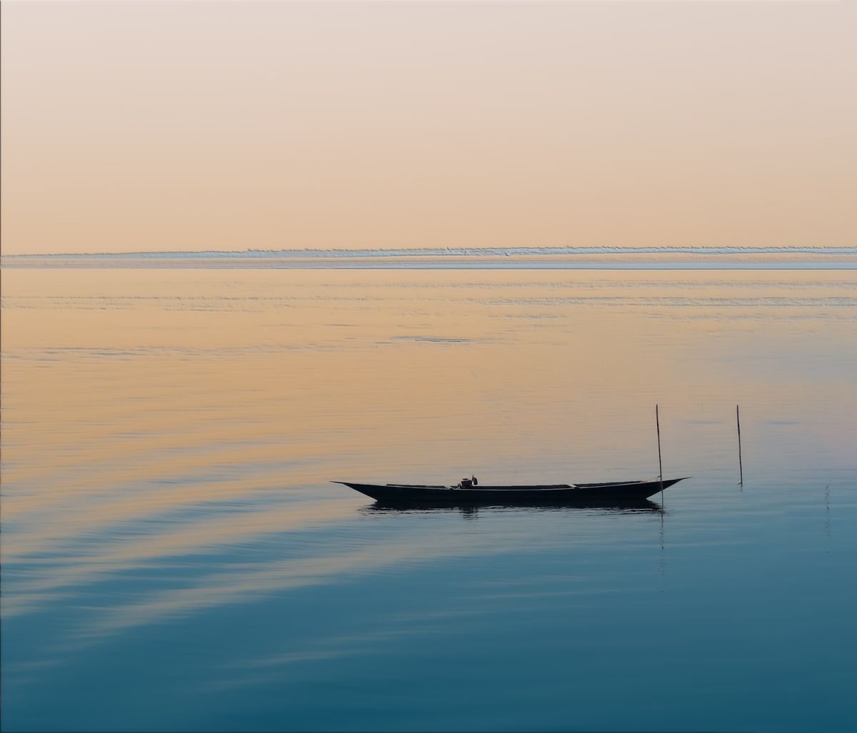 Lone boat crossing calm sea water