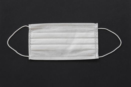 Photo of White Face Mask Against Black Background