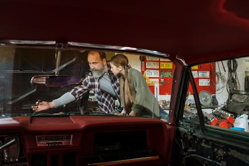 A Mechanic Teaching his Daughter How to Fix a Car