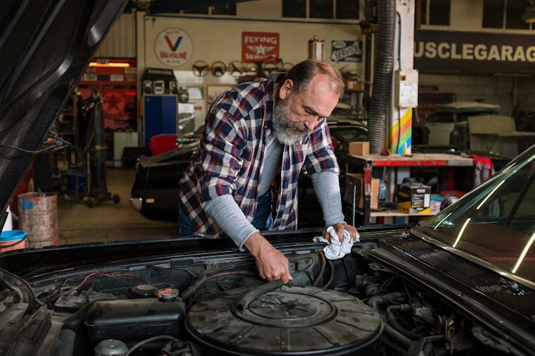 Man In Red White And Black Plaid Dress Shirt Holding Black Car