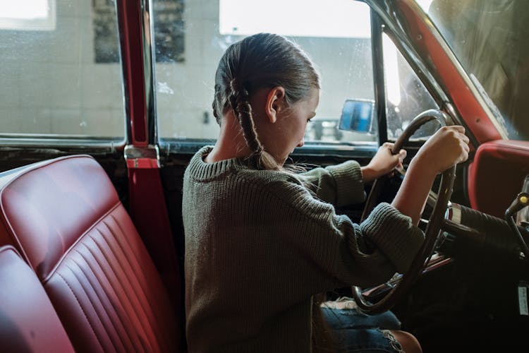 Woman In Gray Sweater Sitting On Red Car Seat