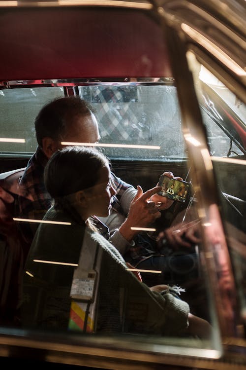 Free Father and Daughter Using a Smartphone while Sitting in the Car Stock Photo