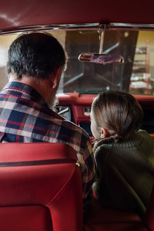 Free Back View of a Man and his Daughter Sitting in the Car Stock Photo