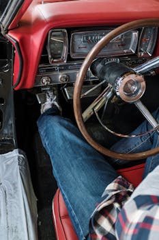 特写镜头聚焦于驾驶老爷车的人，重点展现复古的仪表盘和方向盘