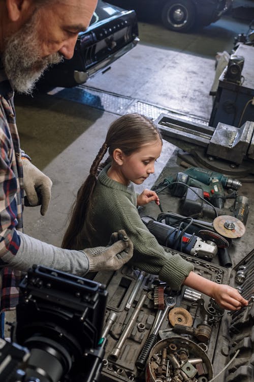 A Girl and her Father Looking at Tools in a Garage