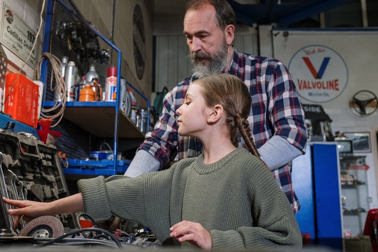 A Man And His Daughter Looking At Tools In A Garage