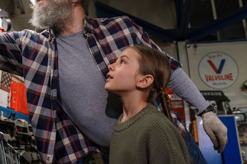 Close up of a Man and his Daughter Looking at Tools in a Garage