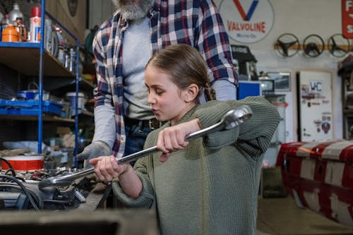 Free A Man and his Daughter Working Together at a Car Service Center Stock Photo