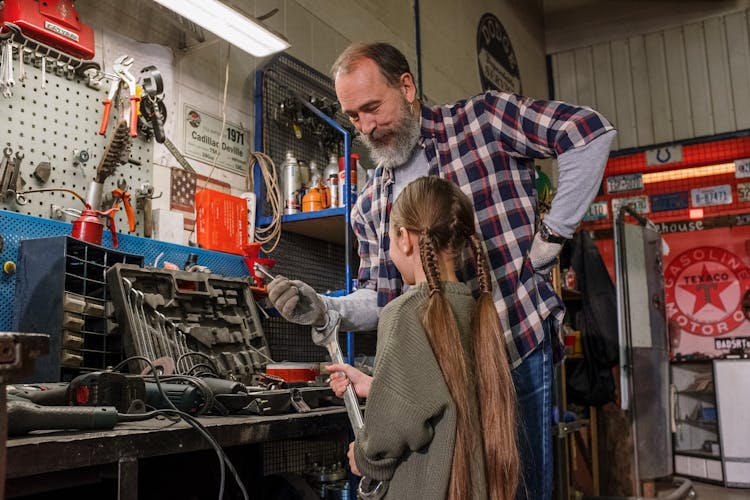 Father And Daughter Looking At Tools In A Garage 