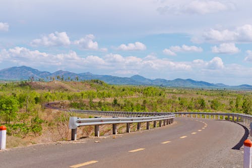 Asphalt road among hilly terrain in highland