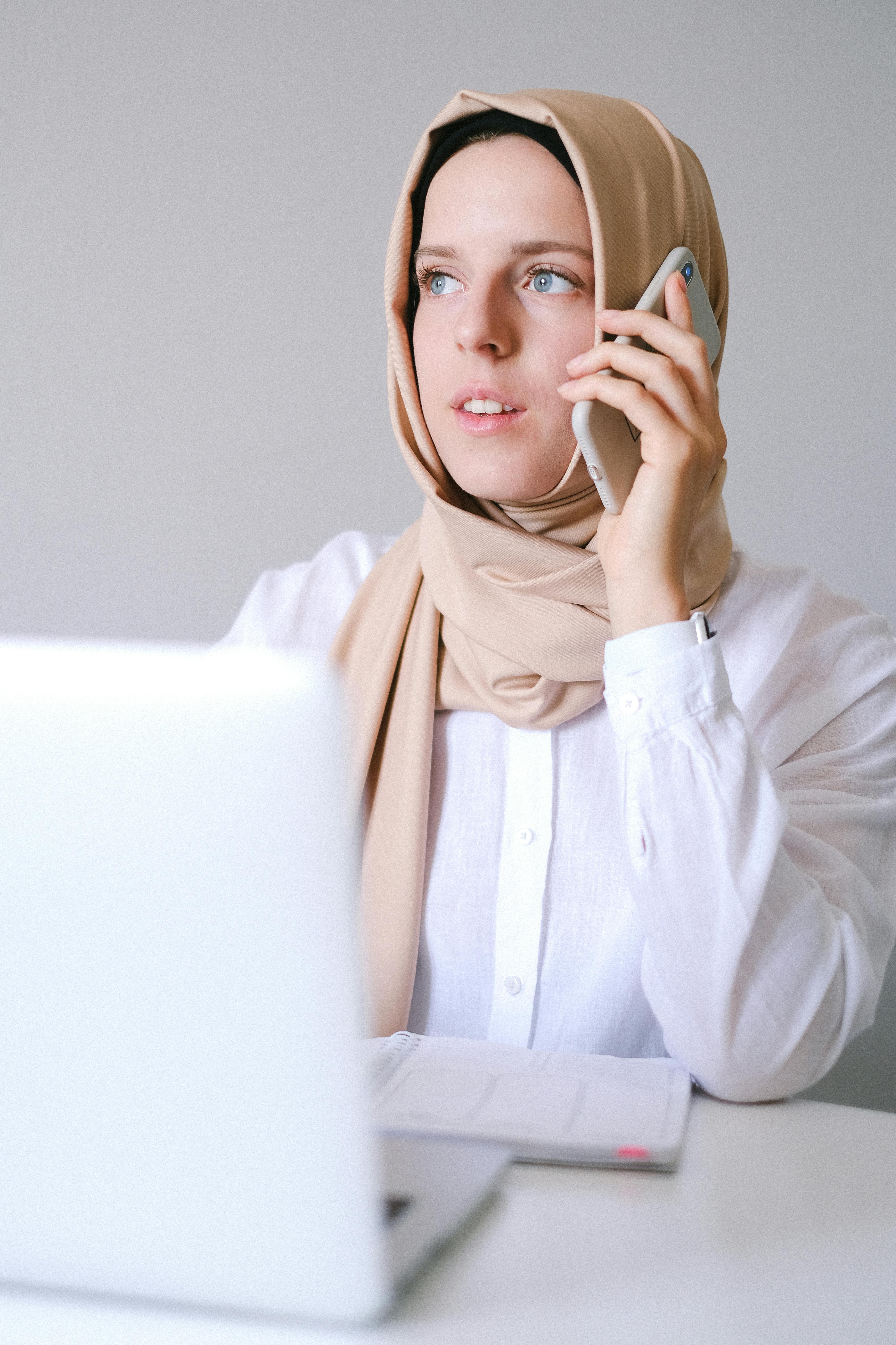 woman in white long sleeve shirt using smartphone