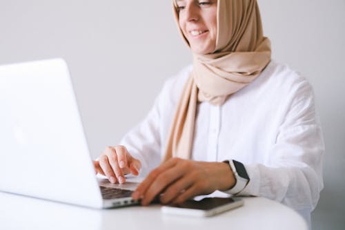 Woman in White Long Sleeve Shirt Using Macbook Air