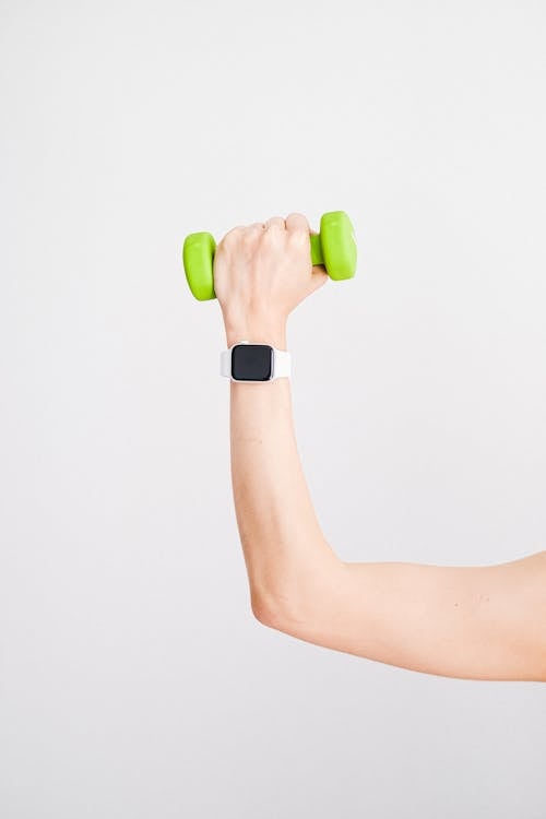 Person Wearing White Apple Watch While Holding Green Dumbbell