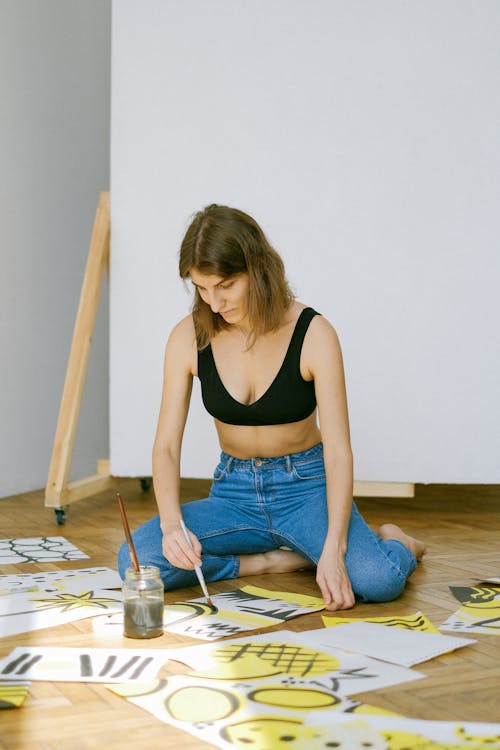 Photo of Woman Sitting on Floor While Painting