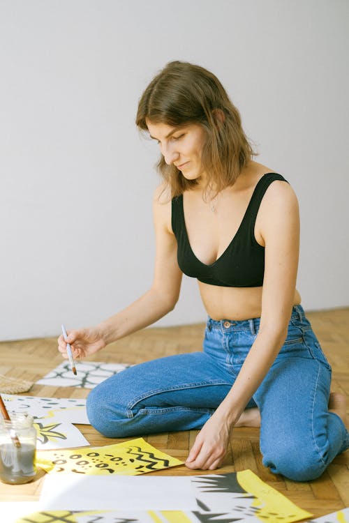 Photo of Woman Sitting on Floor While Painting