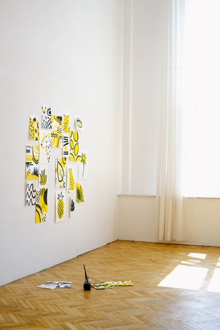 Creative art setup with abstract yellow and black sketches on white walls in a bright studio.
