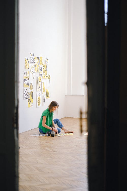 Photo of Woman Sitting on Floor While Painting
